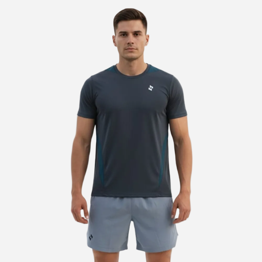 Man wearing a dark gray athletic shirt and gray shorts on a white background