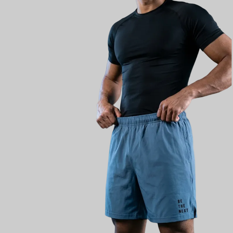 Man wearing a black t-shirt and ocean blue training sopro shorts on a white background