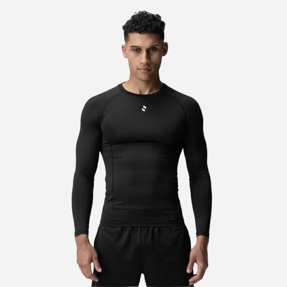 Man wearing a black long-sleeve athletic shirt and shorts on a light background