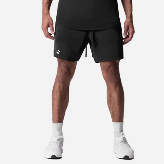 athlete wearing black athletic shorts with a brand logo on a white background